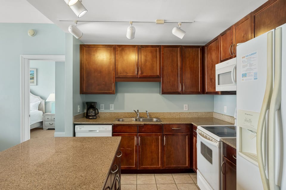 kitchen with wooden cabinets and modern appliances adjacent to the bedroom
