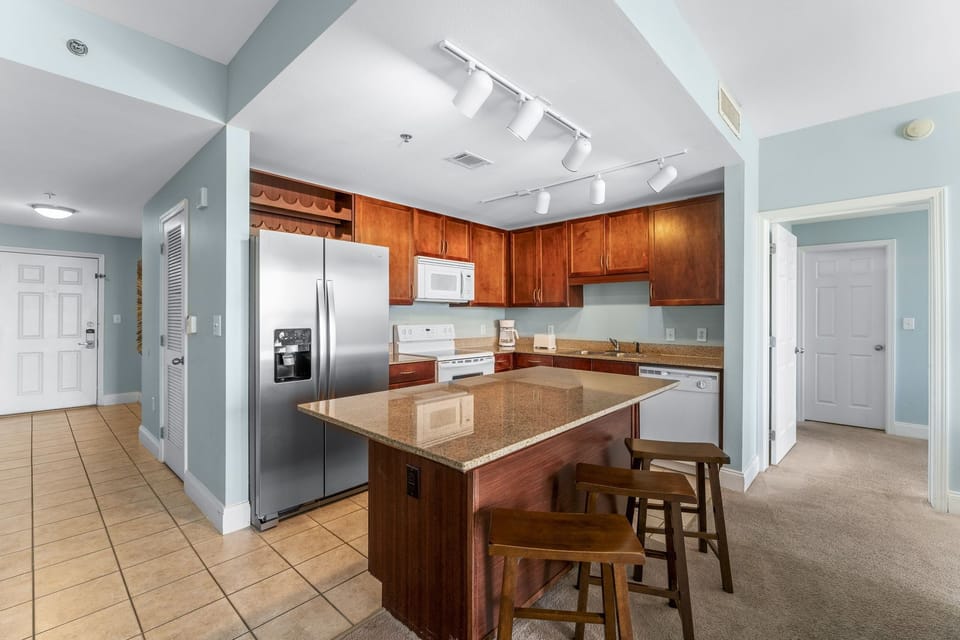 Modern kitchen with stainless steel appliances and a central island for casual dining.