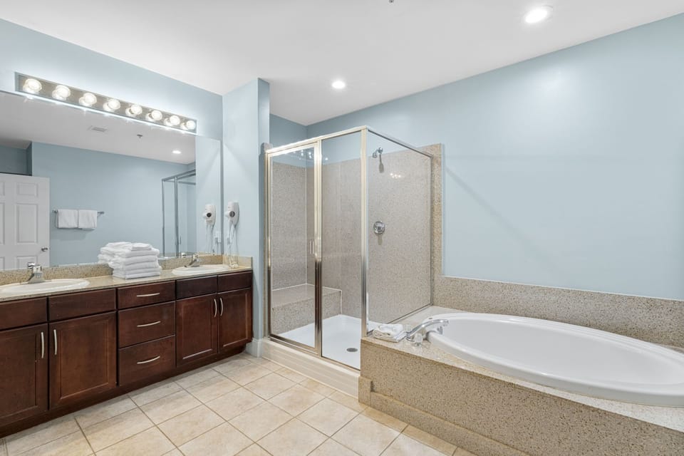Spacious bathroom with a separate glass shower and soaking tub in a modern setting