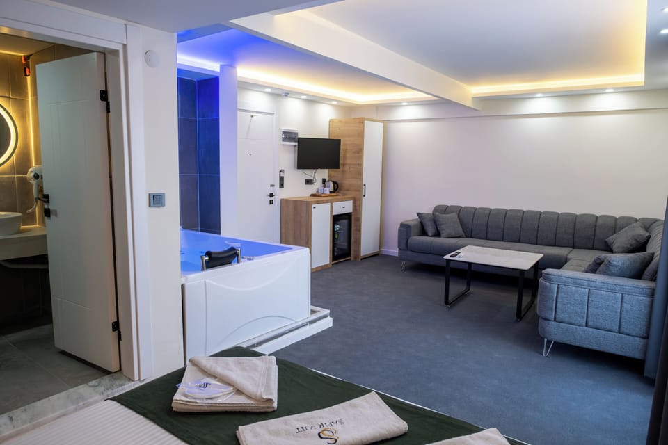 Deluxe Double Room | Living area | 65-inch Smart TV with satellite channels