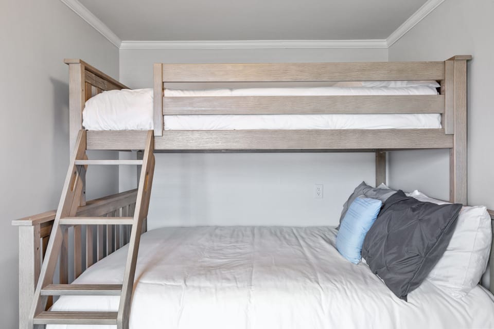 Premium wood bunk bed with a twin and full mattress with comfy bedding and pillows
