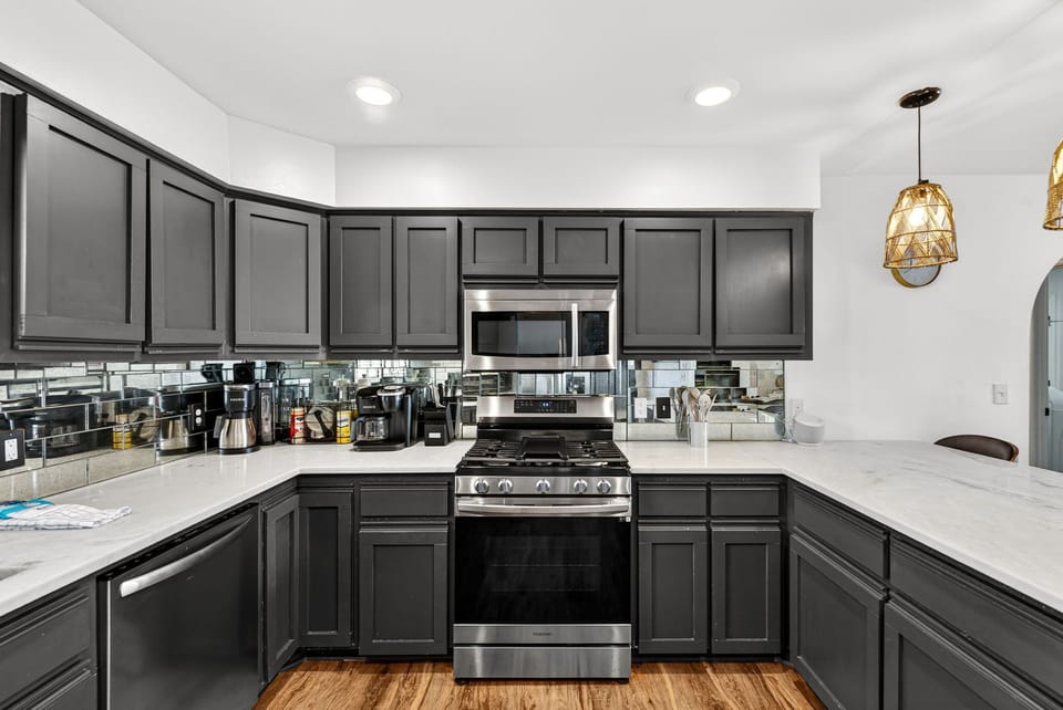 Your spacious kitchen gleams with sleek gray cabinetry, marble countertops, and modern stainless appliances—everything you need to cook up memorable vacation meals together.
