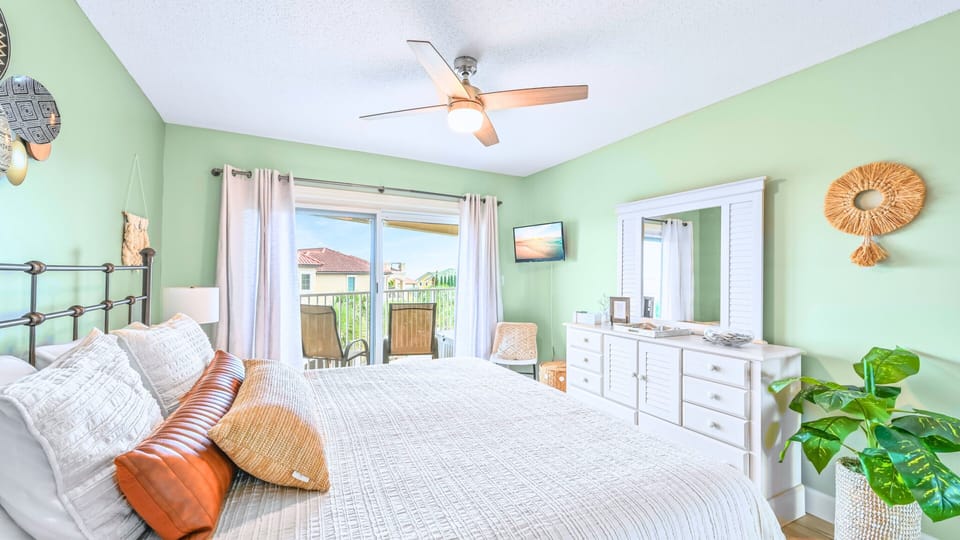 A serene bedroom with balcony access and warm accents.