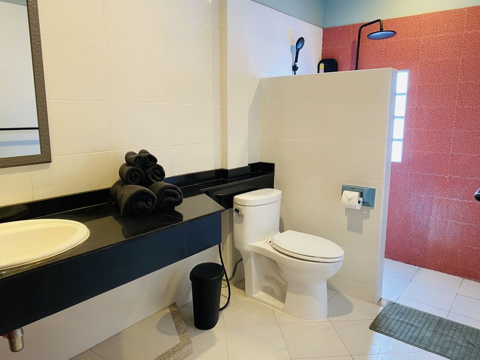Deluxe Room | Bathroom | Shower, rainfall showerhead, hair dryer, towels