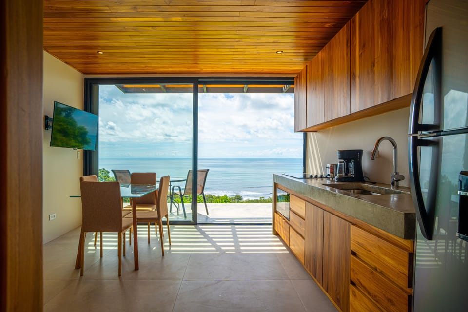 Bright open-concept kitchen and dining area with panoramic ocean views.