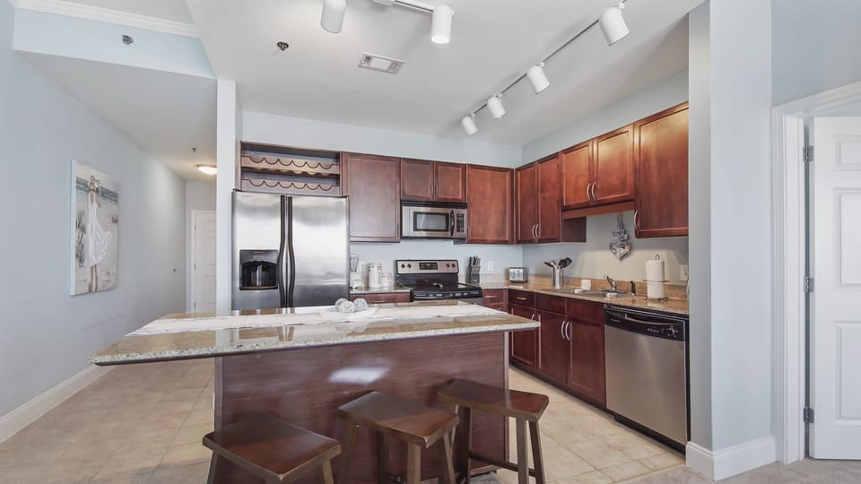 Modern kitchen with stainless steel appliances and a granite island for casual dining.