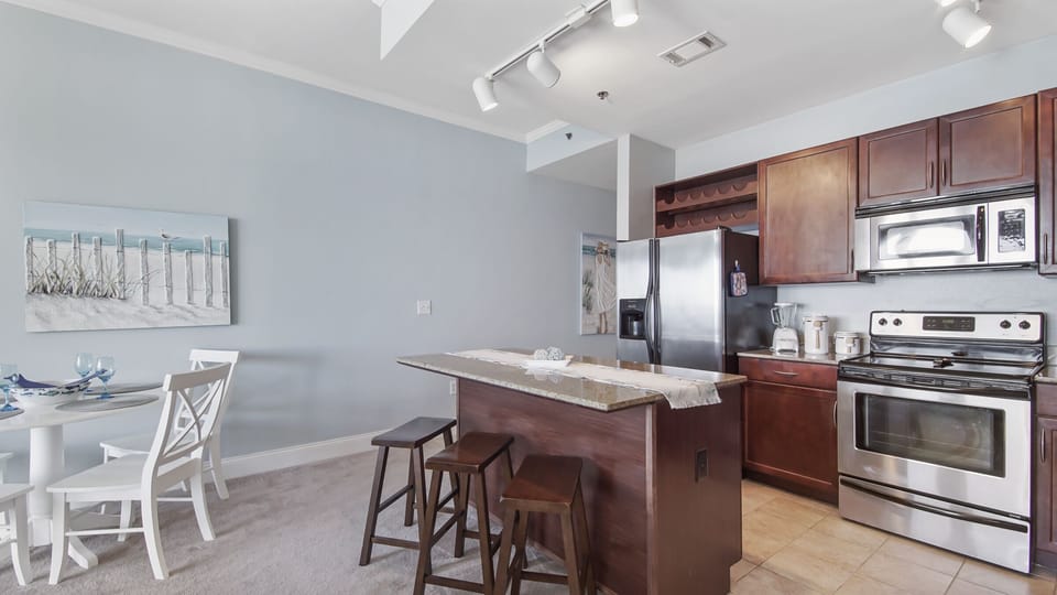 Modern kitchen with stainless steel appliances and a central island with seating.