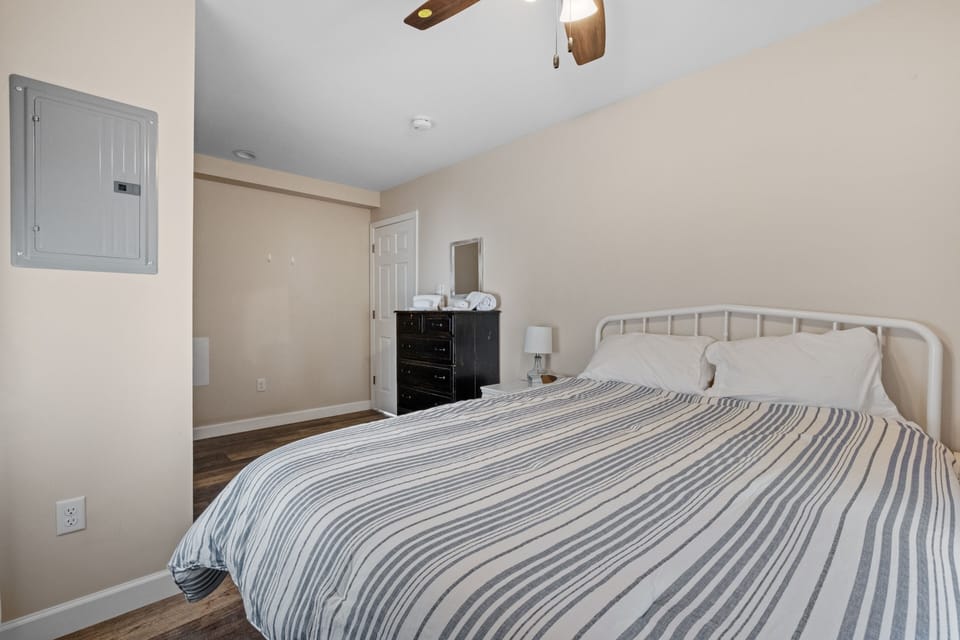 Nightstands with lamps on both sides of the bed, plus a ceiling fan.