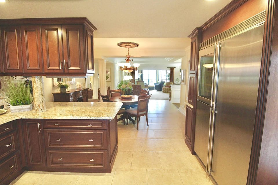 The fully equipped kitchen offers a large stainless steel refrigerator with a separate wine fridge.