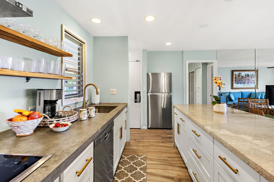 Bright Galley Kitchen with Modern Finishes - Sleek galley kitchen featuring stainless steel appliances, open shelving, and ample counter space flowing into the living area.