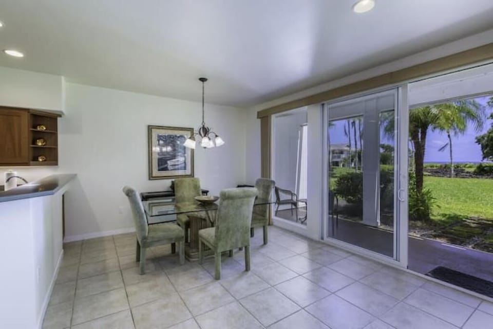 Dining room table with a garden and ocean view that connects to the lanai
