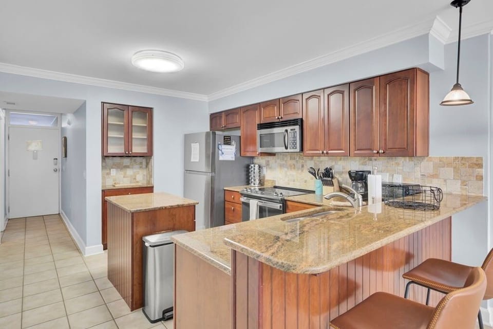 - Spacious kitchen with rich wood cabinetry & sleek stainless appliances - Granite countertops, a center island, & breakfast bar offer plenty of space to prep, & serve - Whether you're brewing coffee or hosting a happy hour, this kitchen has you covered