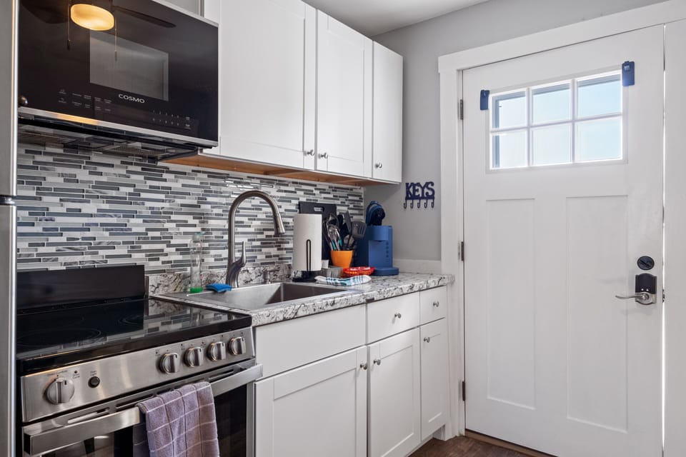 Kitchen stocked with utensils and cookware for preparing meals and dining.