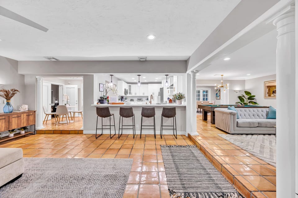 The kitchen has a bar with 4 barstools.
