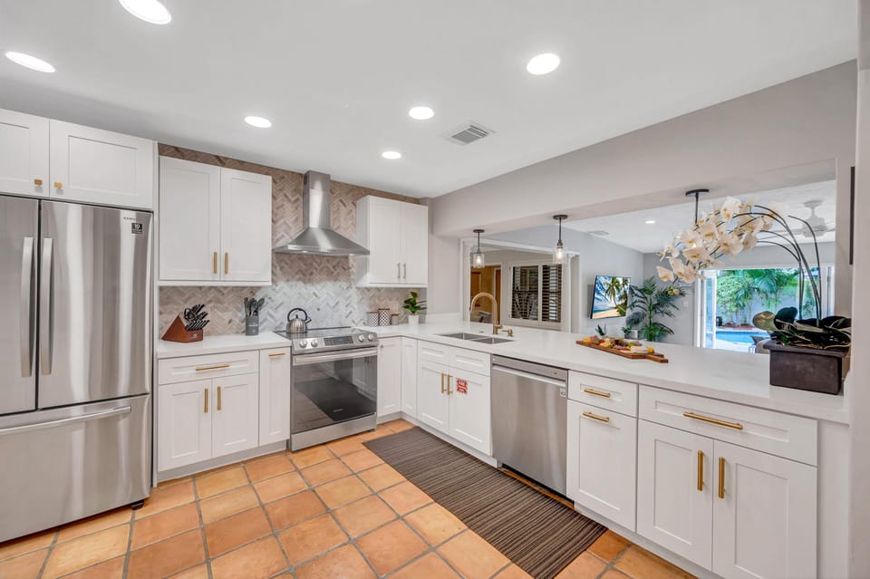 The kitchen is fully equipped and looks over the family rooms with seamless access to the heated pool.