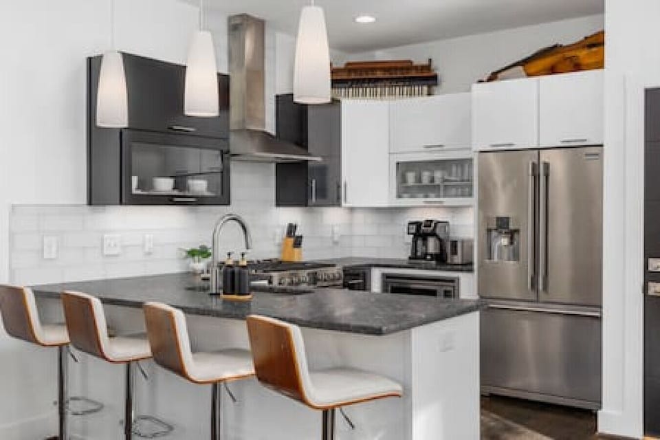Gas range and high-end appliances in this updated, well-equipped kitchen with seating for four at the counter.