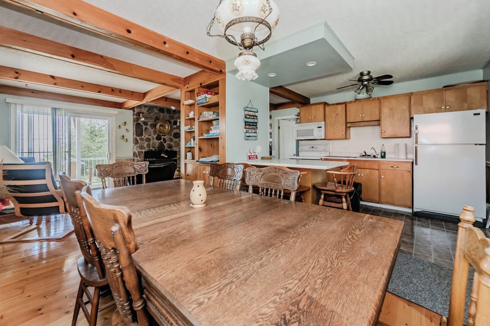 The dining area, flooded with natural light, offers a serene setting for meals. The rustic decor and comfortable seating make it an inviting space for family gatherings and dining.
