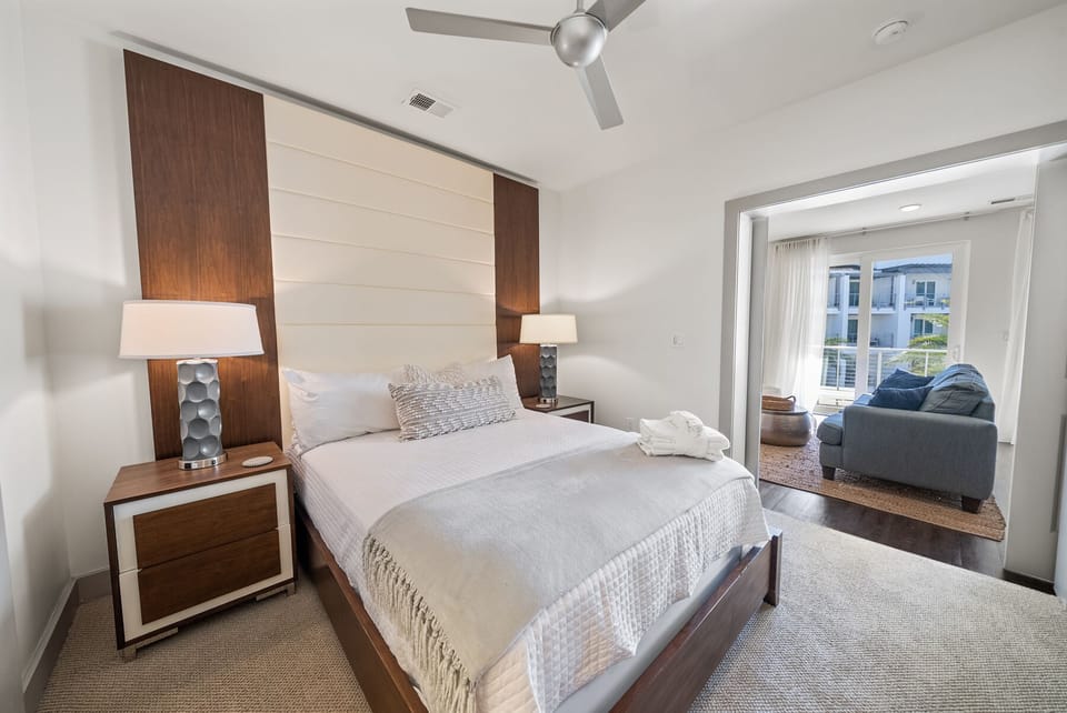 Rest in style with plush bedding and modern wood accents. Your private bedroom flows into a cozy living area where you can unwind.