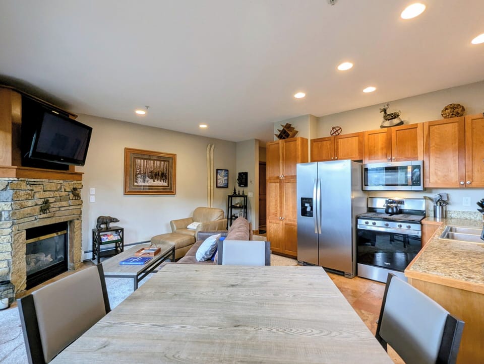 An open-concept retreat where your living and dining areas flow seamlessly together, warmed by a handsome stone fireplace and fully equipped with everything you need to cook, relax, and make yourself at home.