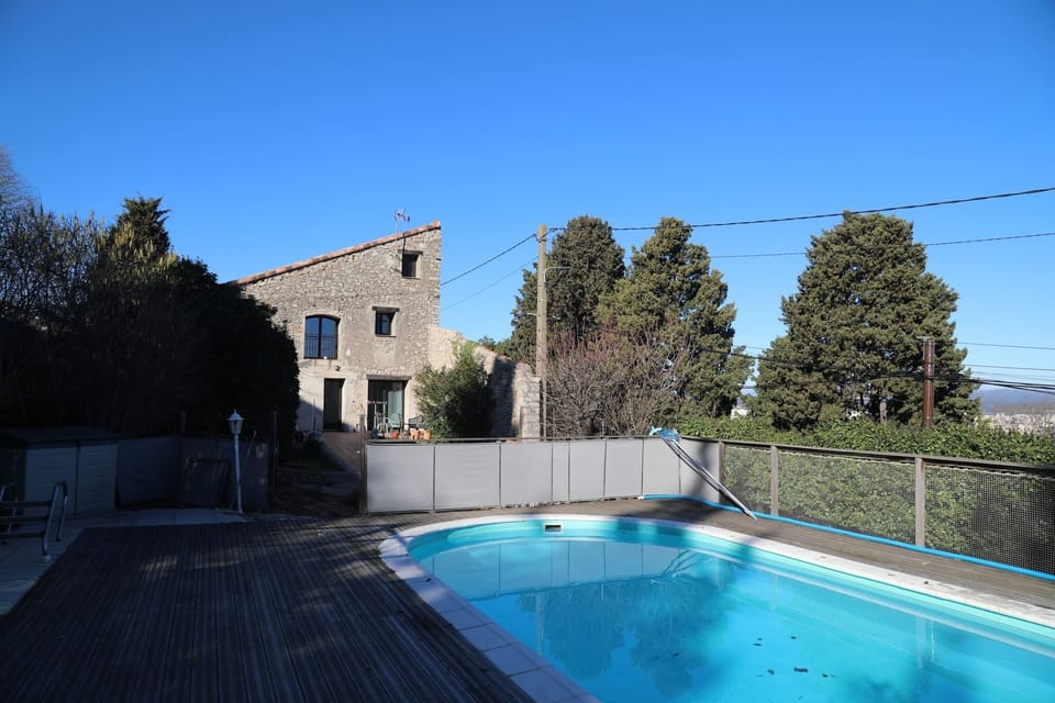 The villa's large swimming pool has a wooden deck for relaxing on the sun loungers.