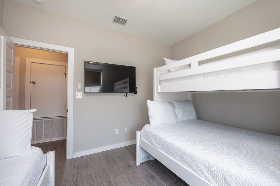 Your family's cozy bunk room features crisp white linens and modern amenities, perfect for kids' adventures and restful nights together.