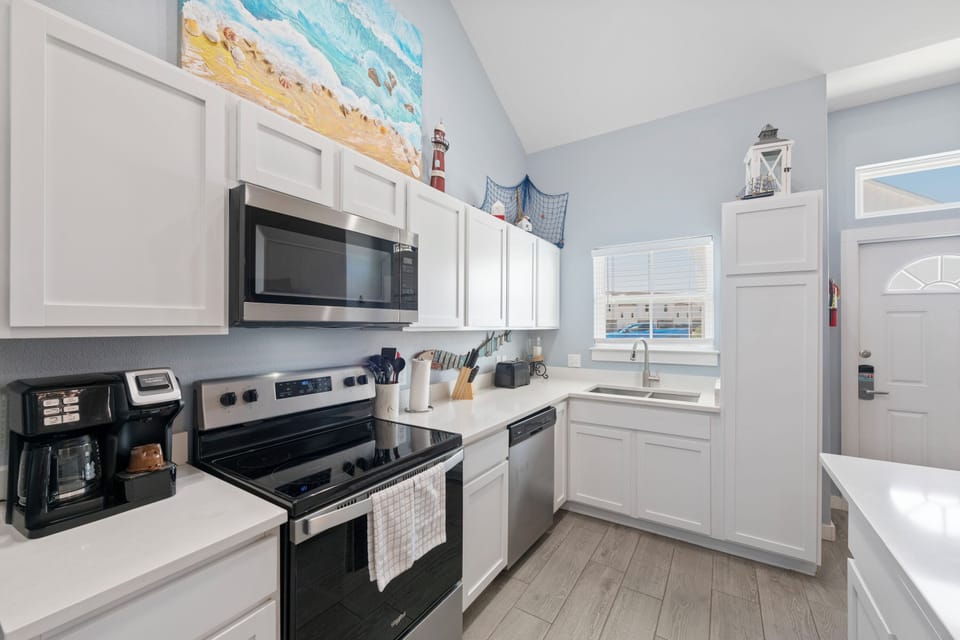 Your fully equipped kitchen awaits with coastal charm, stainless steel appliances, and everything you need to create memorable meals during your stay.