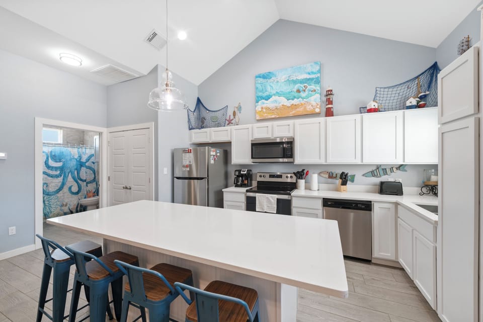 Your spacious kitchen features stainless steel appliances, vaulted ceilings, and charming coastal decor that sets the perfect tone for your getaway.