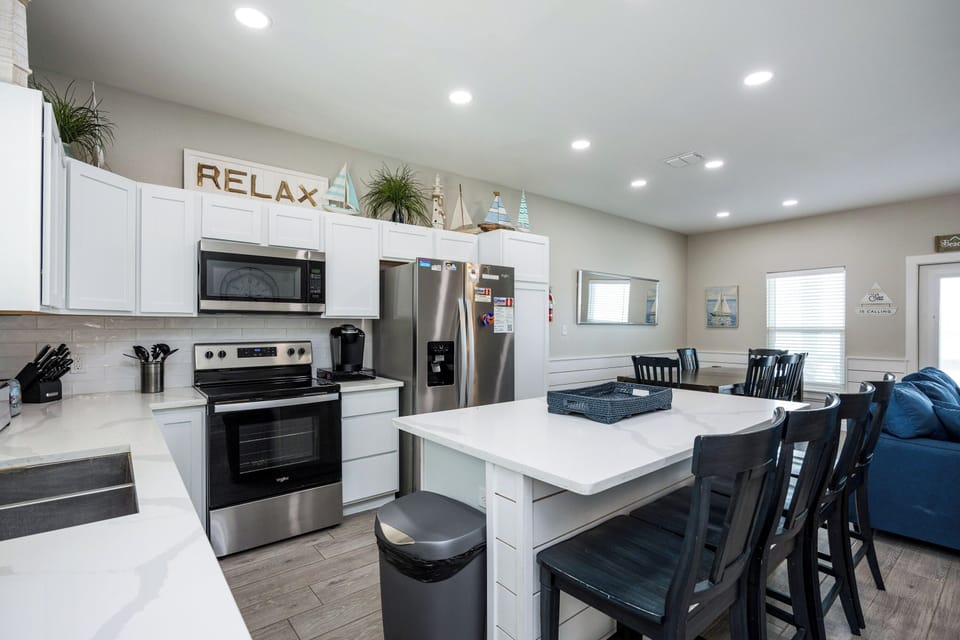 Gather around your spacious kitchen island for morning coffee or evening conversations in this modern, well-equipped space with stainless steel appliances.