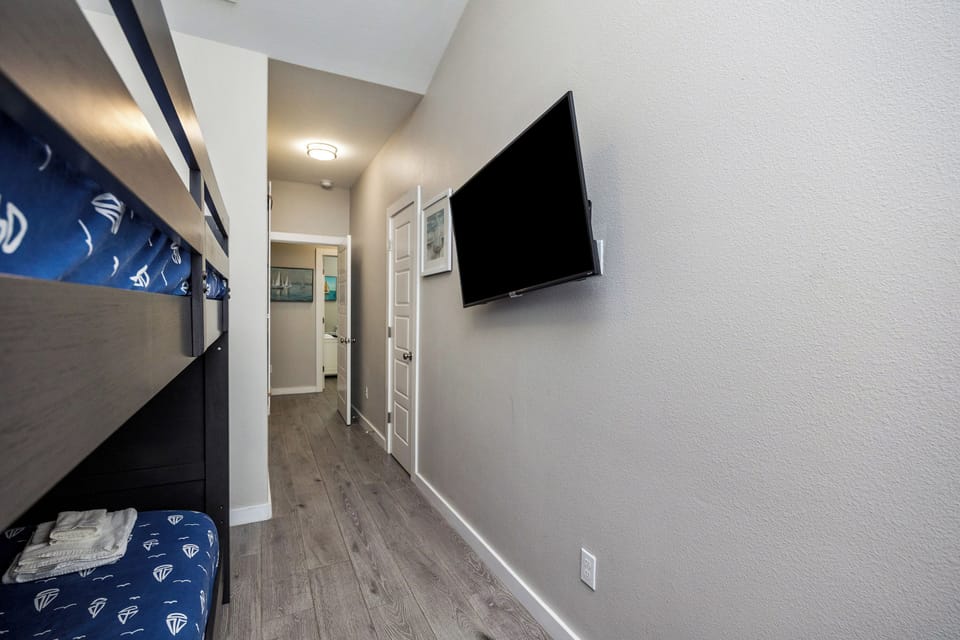 Your modern bunk room features a wall-mounted TV for movie nights and crisp linens in cheerful blue.