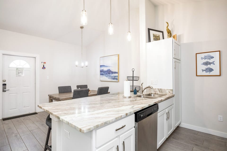 Your bright, open kitchen flows seamlessly into the dining space, perfect for preparing meals and gathering around the beautiful wood table.
