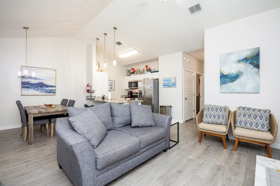 Relax in your bright, open-concept living space with coastal artwork and comfortable seating for memorable evenings together.