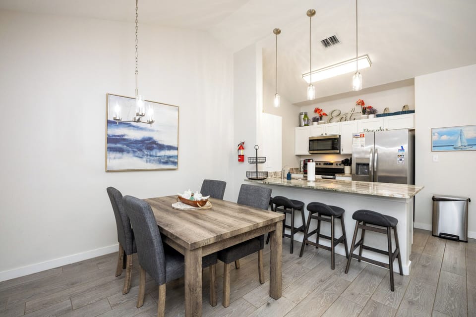 Your open-concept kitchen and dining area blends seamlessly with coastal artwork and granite countertops for memorable gatherings.