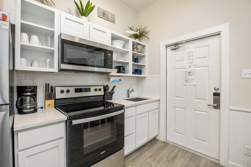 Your fully equipped kitchen awaits with modern appliances, crisp white cabinets, and everything you need to create delicious meals during your stay.