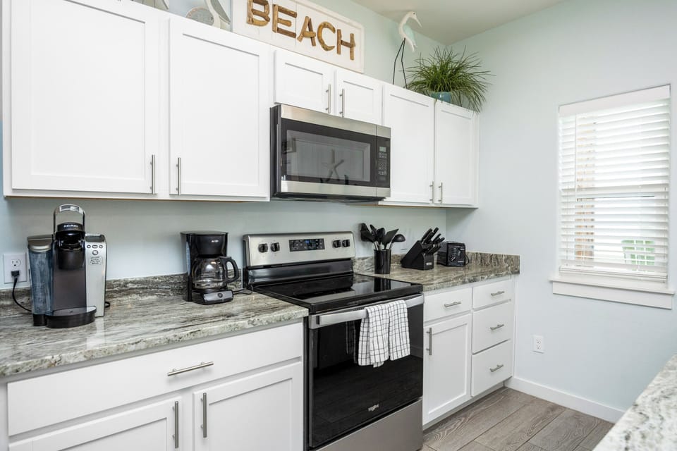 Your fully equipped kitchen awaits with modern appliances and coastal charm, perfect for brewing morning coffee or preparing beachside meals.