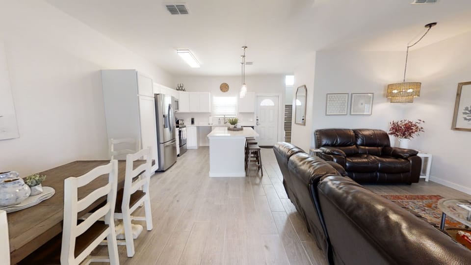 Your open-plan living space blends modern comfort with warmth, featuring a sleek kitchen, cozy leather seating, and stylish touches throughout.