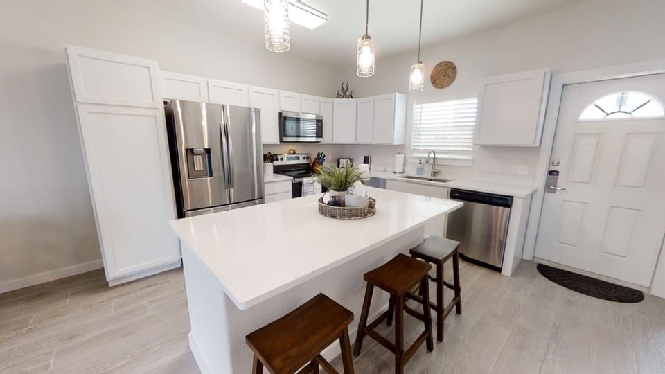 Your modern kitchen awaits with gleaming appliances, spacious quartz countertops, and warm pendant lighting creating the perfect space for memorable meals.