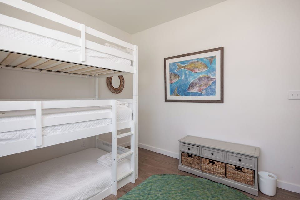 Perfect for kids or groups, your cozy bunk bed room features crisp white linens and charming coastal artwork that sets a peaceful tone.