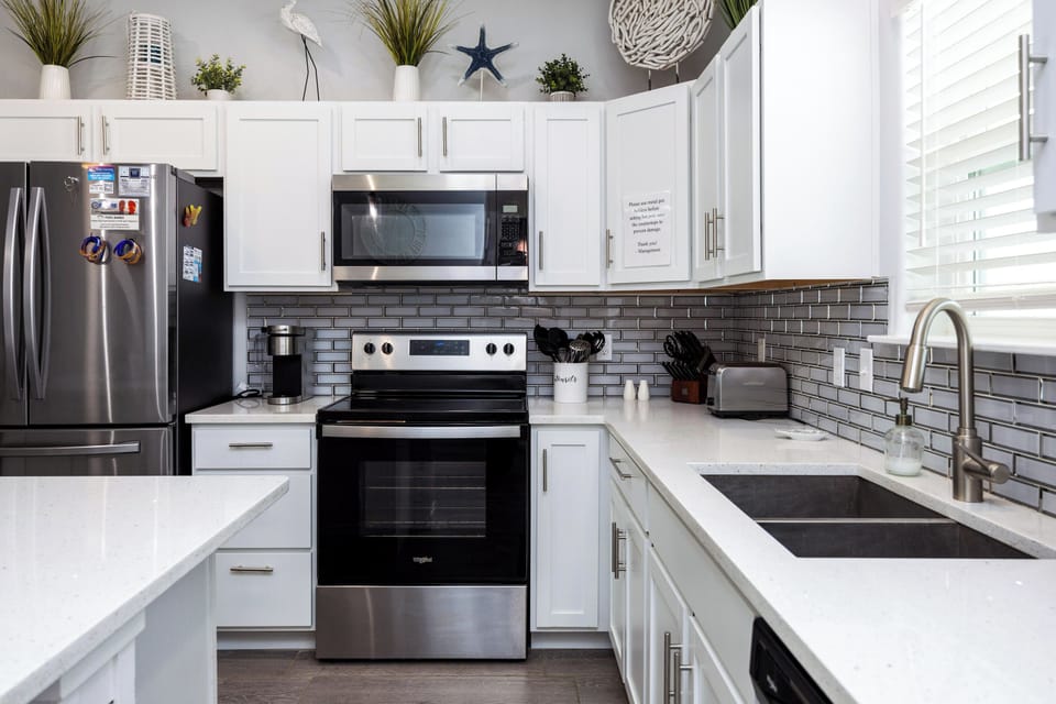 Your fully equipped kitchen awaits with stainless steel appliances, quartz counters, and coastal-inspired touches perfect for preparing memorable meals.
