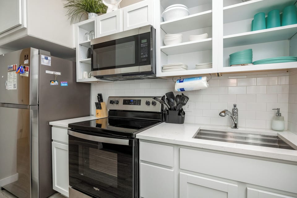 Step into your fully equipped kitchen, where white cabinets and modern appliances await your culinary adventures.