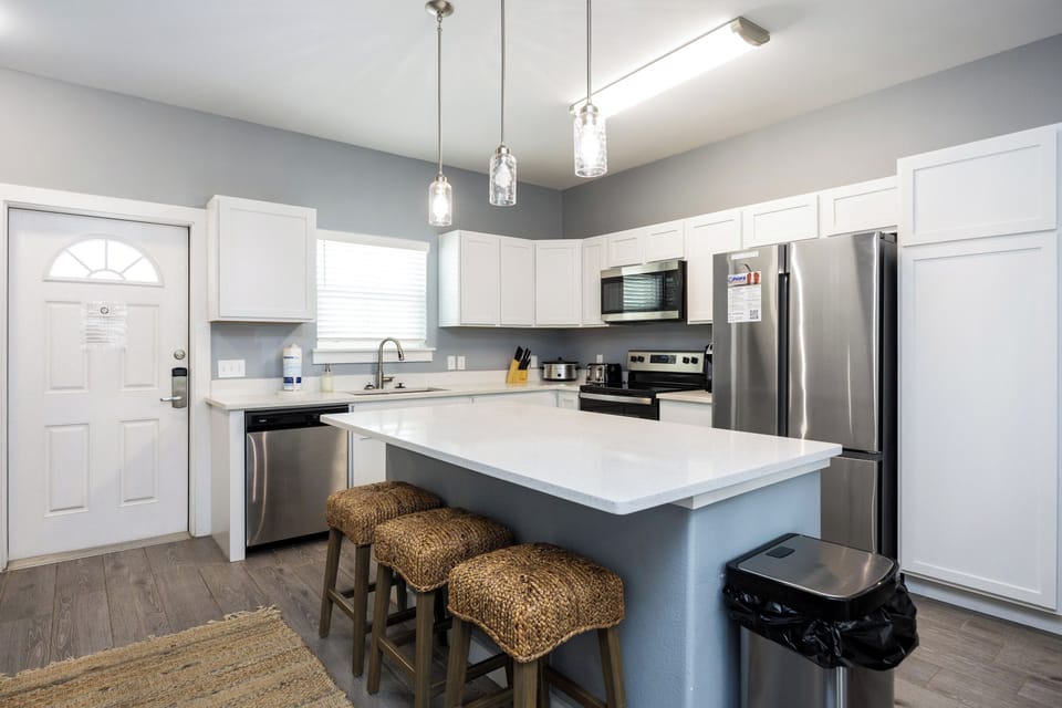 Your modern kitchen awaits with gleaming countertops, stainless steel appliances, and cozy seating for morning coffee or evening conversations.