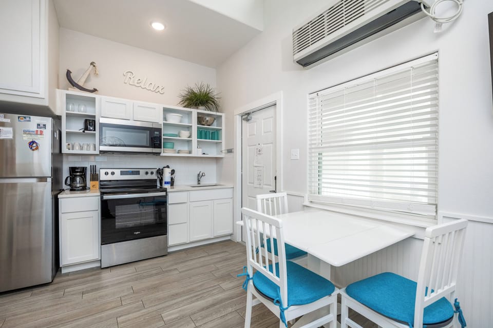 Your bright, fully-equipped kitchen invites morning coffee prep and easy meal planning with modern appliances and cheerful coastal touches.