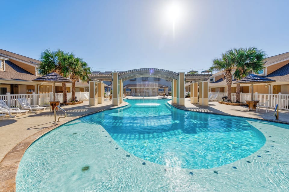 Stunning resort-style pool with elegant archway and palm trees creates a tropical paradise for your perfect getaway.
