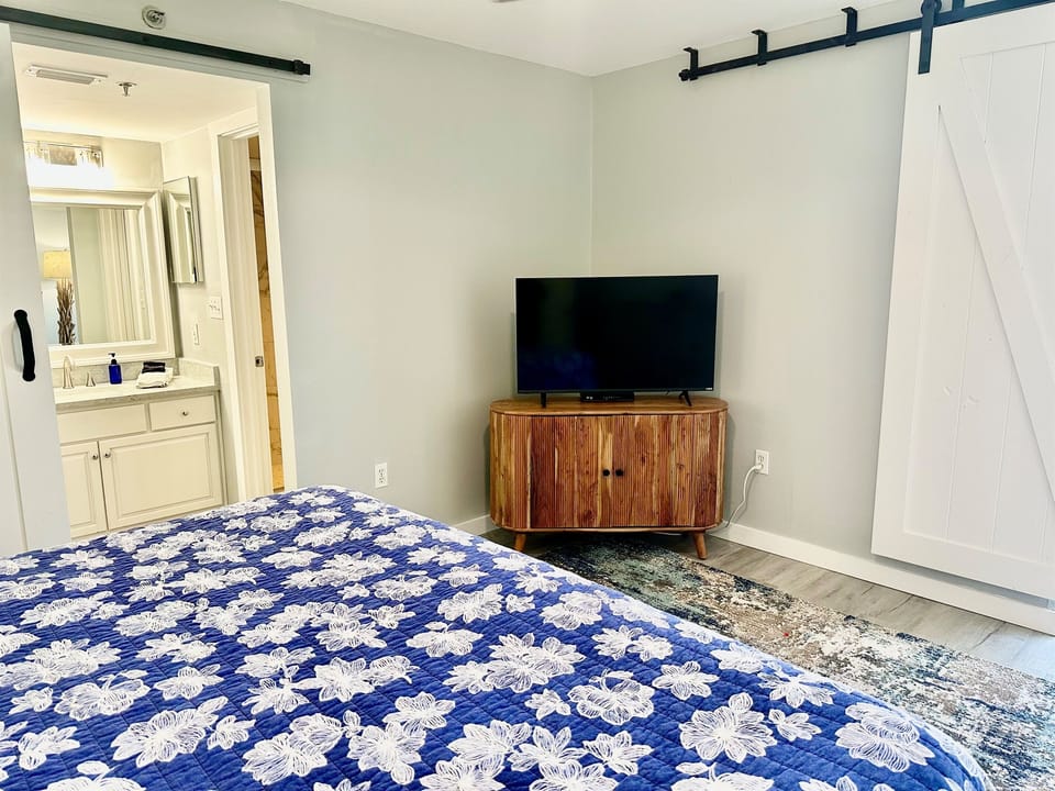 Smart tv and entrance to the master bathroom.