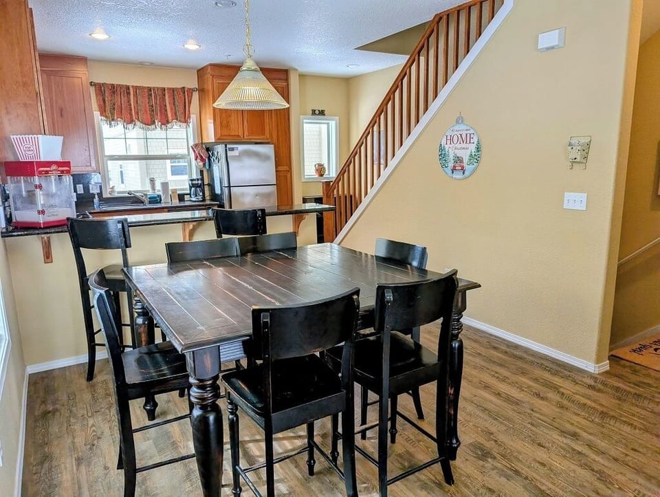 Large dining table with seating for 6, plus 2 stools at the breakfast bar