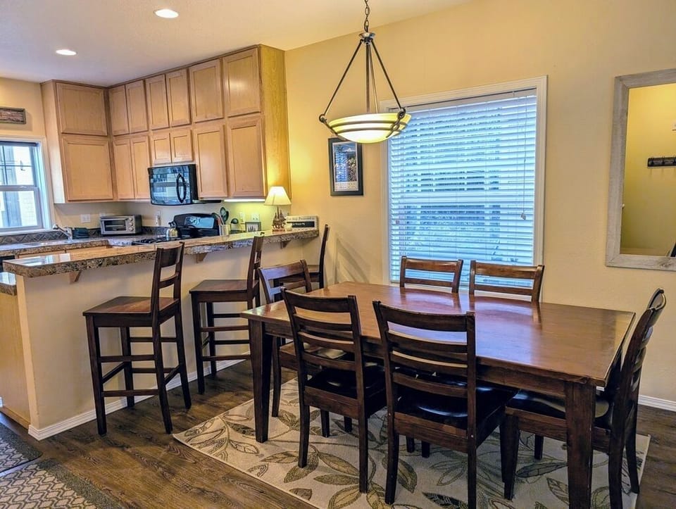 Large dining table with seating for 6, plus 3 stools at the breakfast bar.