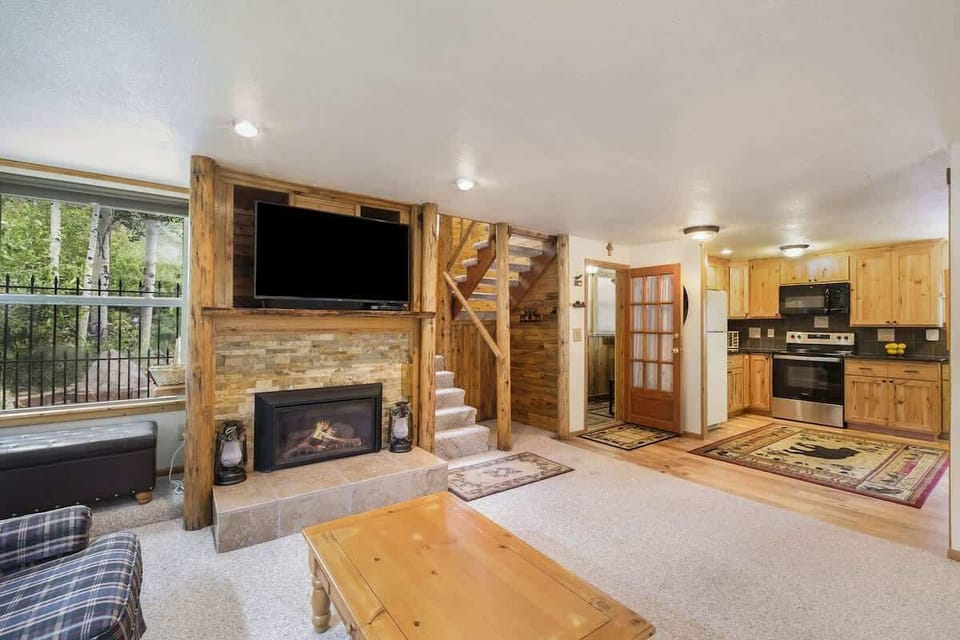 Living room has a cozy fireplace and large TV.