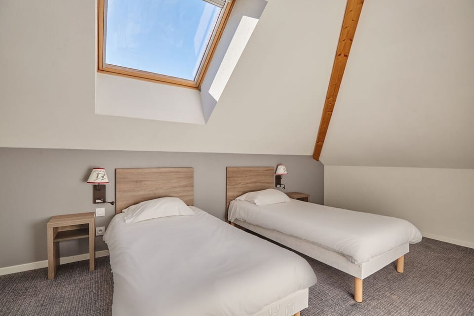 Bedroom with two single beds beneath a skylight
