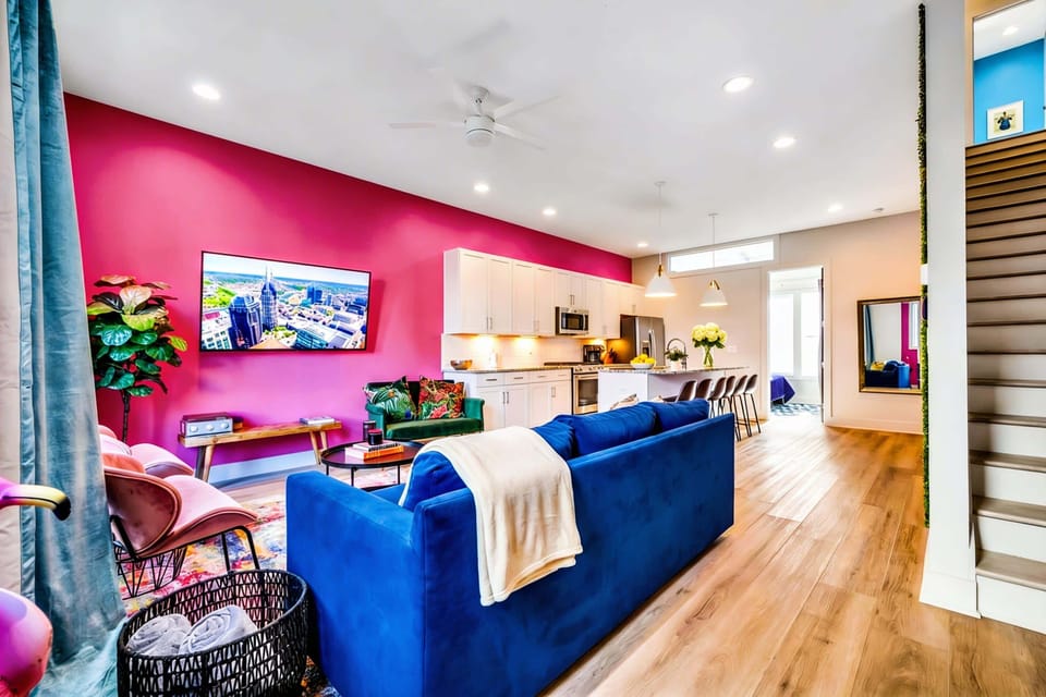 Bold pink accent wall behind the TV in the living room adds energy to the space where your group will gather after nights exploring Tennessee's music scene