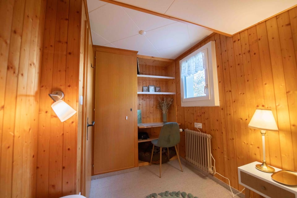 A small workspace with a desk and wooden panelling