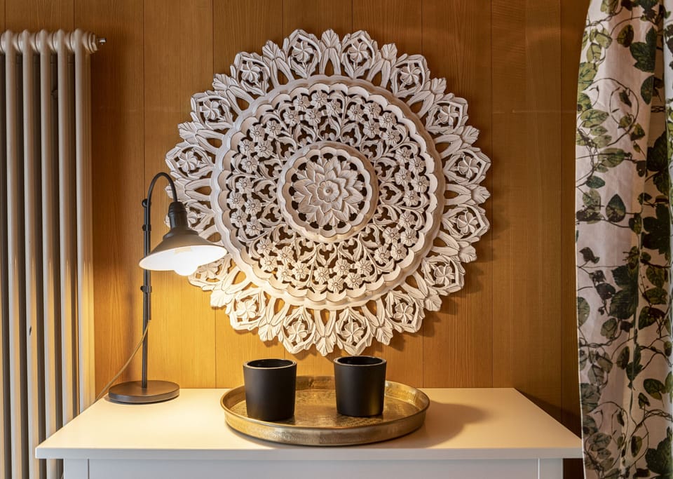 Decorative wall display with a lamp and candles on the chest of drawers